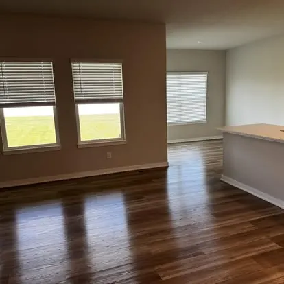 Freshly cleaned, move-out-ready room with polished hardwood floors and clear space