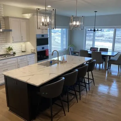 Freshly cleaned residential kitchen and dining area with a gleaming quartz island