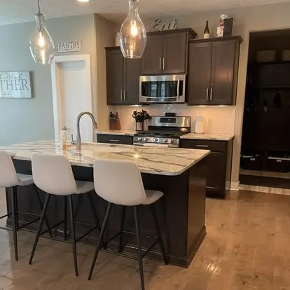 Neatly organized kitchen with a granite island, tidy pantry, and clutter-free counters