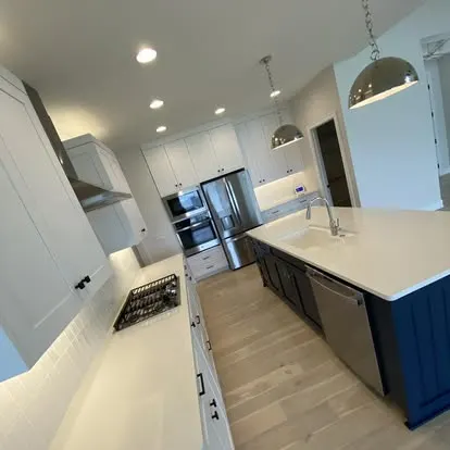Freshly cleaned residential kitchen with a blue island and spotless stainless appliances